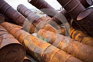 Rusted barrels on the shore.