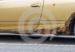 Rusted car body. Close-up of an old rusty leaky yellow car