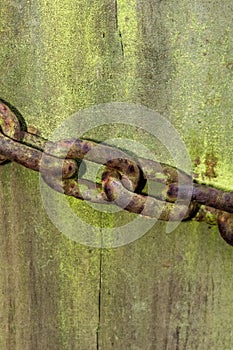 Rusted chain on an old gate post