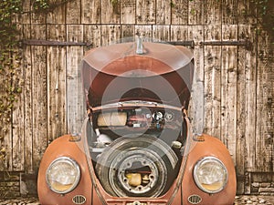 Rusted classic car in front of an old barn door