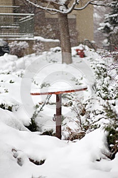 A rusted crank wheel covered in snow