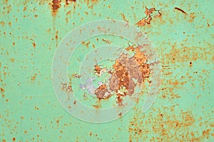Rusted green painted metal wall. Rusty metal background with streaks of rust. Rust stains. The metal surface rusted spots