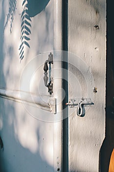 Rusted latch lock white door. Front closeup shot of an old plank door of a barn locked