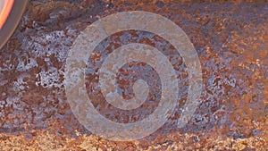 rusted metal surface is being cleaned with angle grinder and a flap disc, full-frame closeup