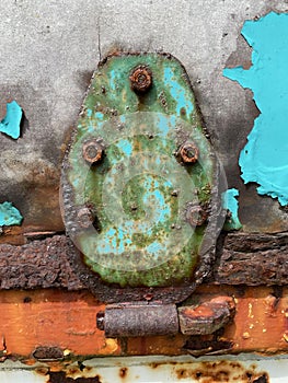 Rusted multicolored hinge on destressed wall