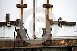 The rusted old trailer is closed to padlocks and tied with a rub