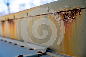 Rusted and peeling paint on an electrical transformer exposed to the elements.
