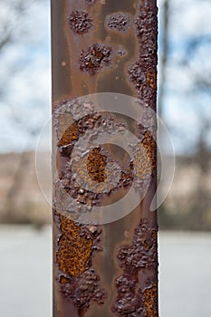 Rusted post with paint blistering off.