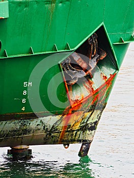 Rusted Raised Anchor on Dark Green Ship
