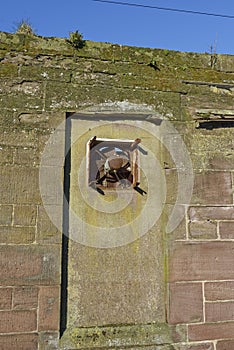 A rusted and seized Ventilation Fan in an old bricked up window space in a derelict Warehouse