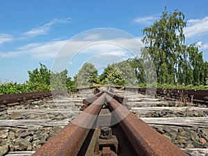 Rusted tracks of a disused railroad line lead to nowhere