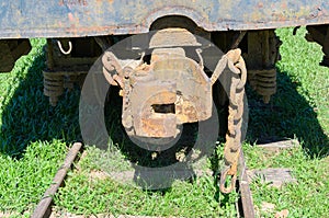Rusted train hitch and chains over rail of a abandoned train