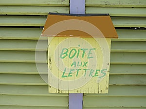 Colorful Rusted yellow mailbox with text `boite aux lettres` mailbox in french photo