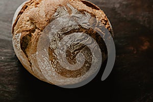 Rustic bread, covered in flour, on wooden table photo