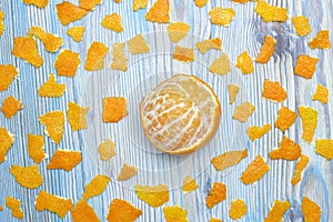Rustic background. Exotic fruits. An overhead photo of tangerine without peel. Peeled juicy tangerine on the wooden blue table and