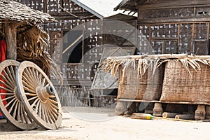 Rustic backyard with bamboo hut, baskets and two wooden wheels