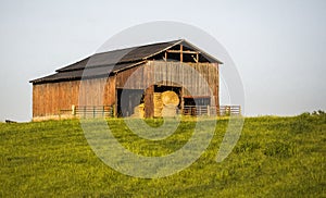 Rustic Barn with Big Round Hay Bales inside the Door