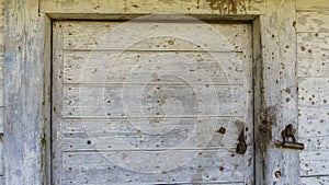 Rustic barn white door. Wooden planks and locks closeup. Peeling paint and weathered. Space for text