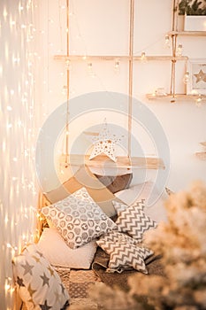 Rustic bedroom interior decorated for Christmas. New Year`s interior Scandinavian style bed with pillows. Textural light room of a