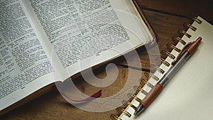 Rustic Bible on a Wooden Background with Notepad