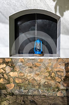 Rustic blue lantern in an exterior window, stucco and stone walls, Arusha, Tanzania