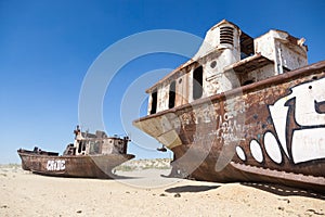 Rustic boats on a ship graveyards on a desert around Moynaq, Muynak or Moynoq - Aral sea or Aral lake - Uzbekistan in Central Asia