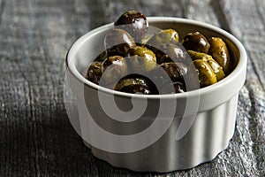 Rustic bowl of olives on wood