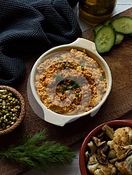 Rustic carrot hummus on wooden board