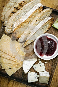 Rustic cheese board platter with bread and redcurrant jam