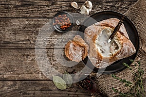 Rustic chicken soup with mushrooms in bread with spices on rustic wooden background. Healthy food concept, top view, flat lay