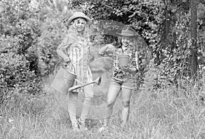 Rustic children nature background. Agriculture concept. Girls in hats planting plants. Sisters helping at farm. Family