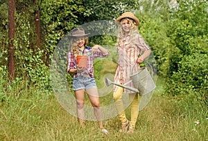 Rustic children nature background. Agriculture concept. Girls in hats planting plants. Sisters helping at farm. Family