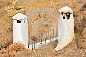 Rustic chimneys of cave houses photo