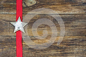 Rustic Christmas Star on wooden board with red ribbon.