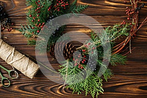 Rustic christmas wreath on wooden table flat lay, holiday workshop