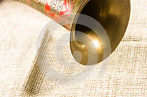rustic coarse canvas fabric and a copper jug with ornament, close-up, background