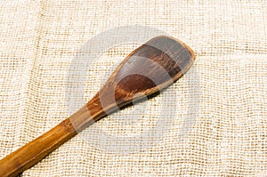 Rustic coarse canvas fabric and a worn wooden spoon, close-up, background