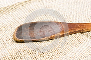 rustic coarse canvas fabric and a worn wooden spoon, close-up, background