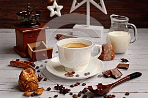 Rustic composition of a cup of coffee  cookies  chocolate  a coffee grinder  a jug of milk on a wooden background