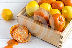 Rustic crate with whole fruit lemons and clementines