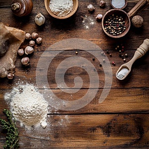 Rustic culinary ingredients on wooden table with flour and spices