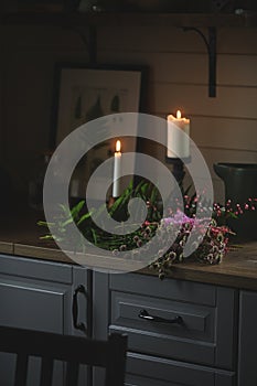 rustic dark wooden cottage kitchen in grey and brown colors with candles and summer garden flowers bouquet.