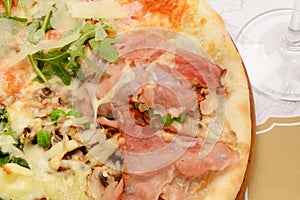 Rustic deep dish pizza with mozzarella cheese, salami, ham, black olives, mushrooms, spices and fresh basil.