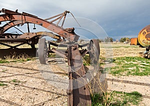 Rustic early road grader and gas container