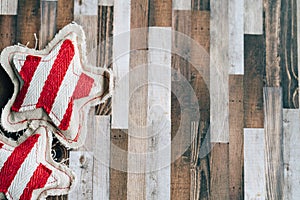 Rustic fabric red and beige stars on a wood plank background, useful for Christmas holiday projects