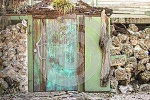 Rustic faded aqua garden doorway surrounded by a rock wall in Key West, Florida