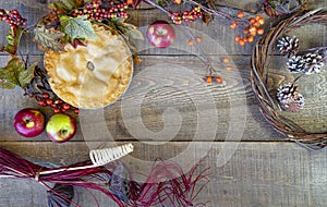 Rustic fall decor and apple pie on wood plank background