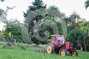 Rustic farm tractor in summer garden