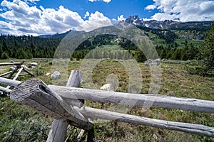 Rustic fence with the Grand Teton mountain range in the background in Wyoming USA during summer on a sunny day