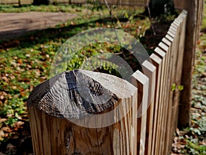 a rustic fence made of natural planks and posts sharpened to